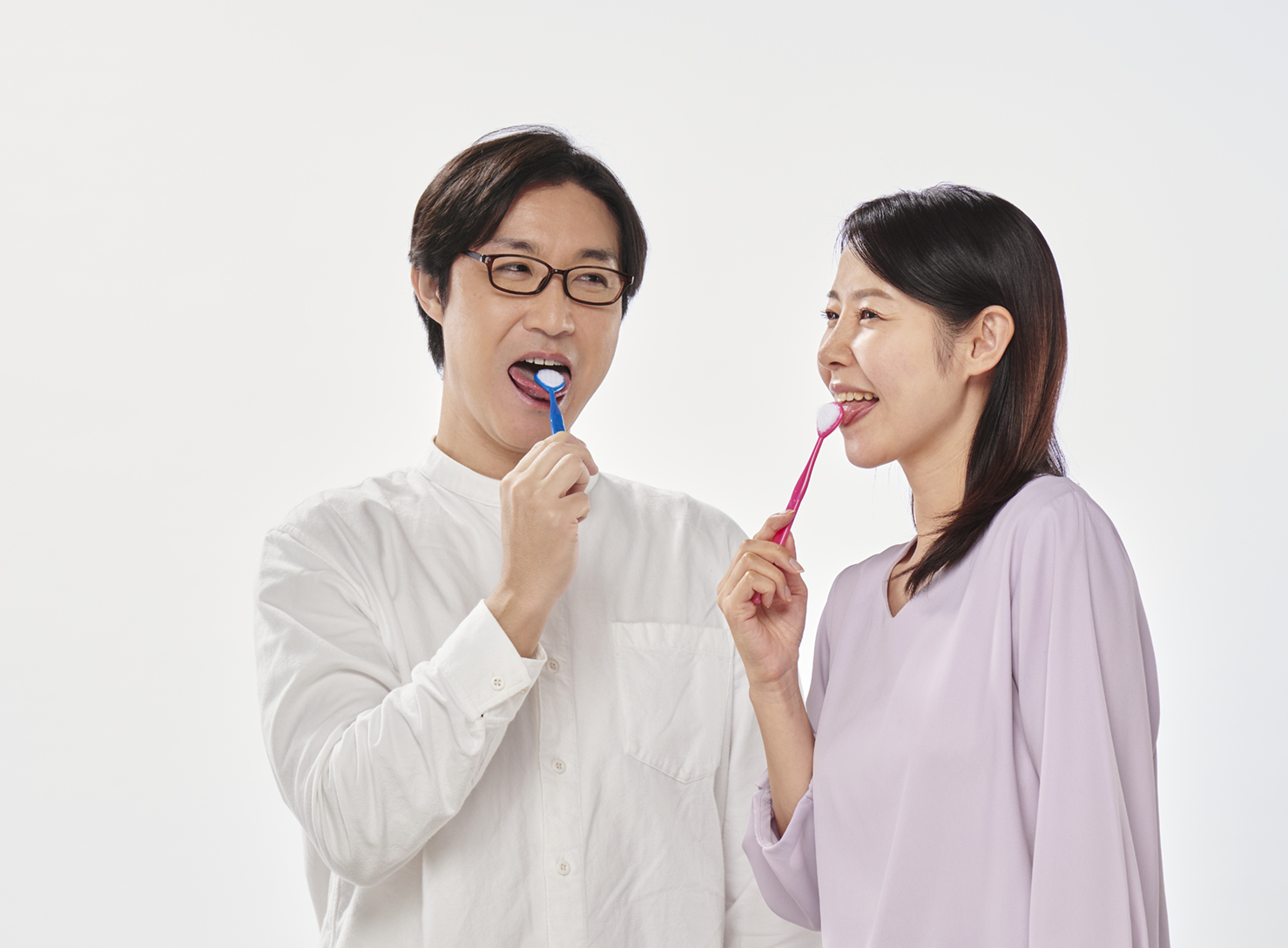 舌ブラシで舌みがきをする男性と女性