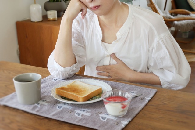 食事中に口元の違和感を気にする女性